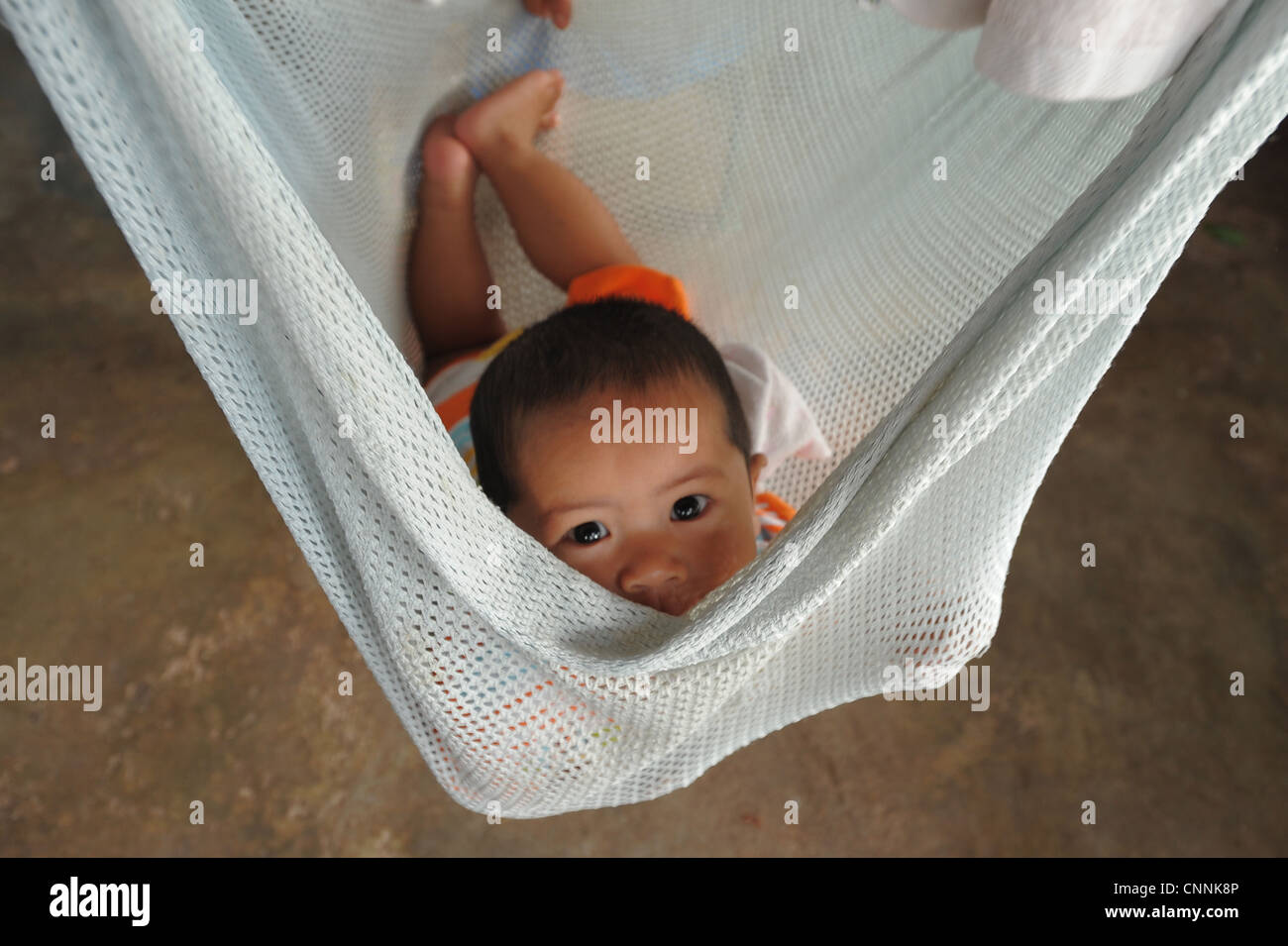 Bébé garçon se détendre dans son swing bed, communauté musulmane , ko sukon, trang , au sud de la Thaïlande Banque D'Images
