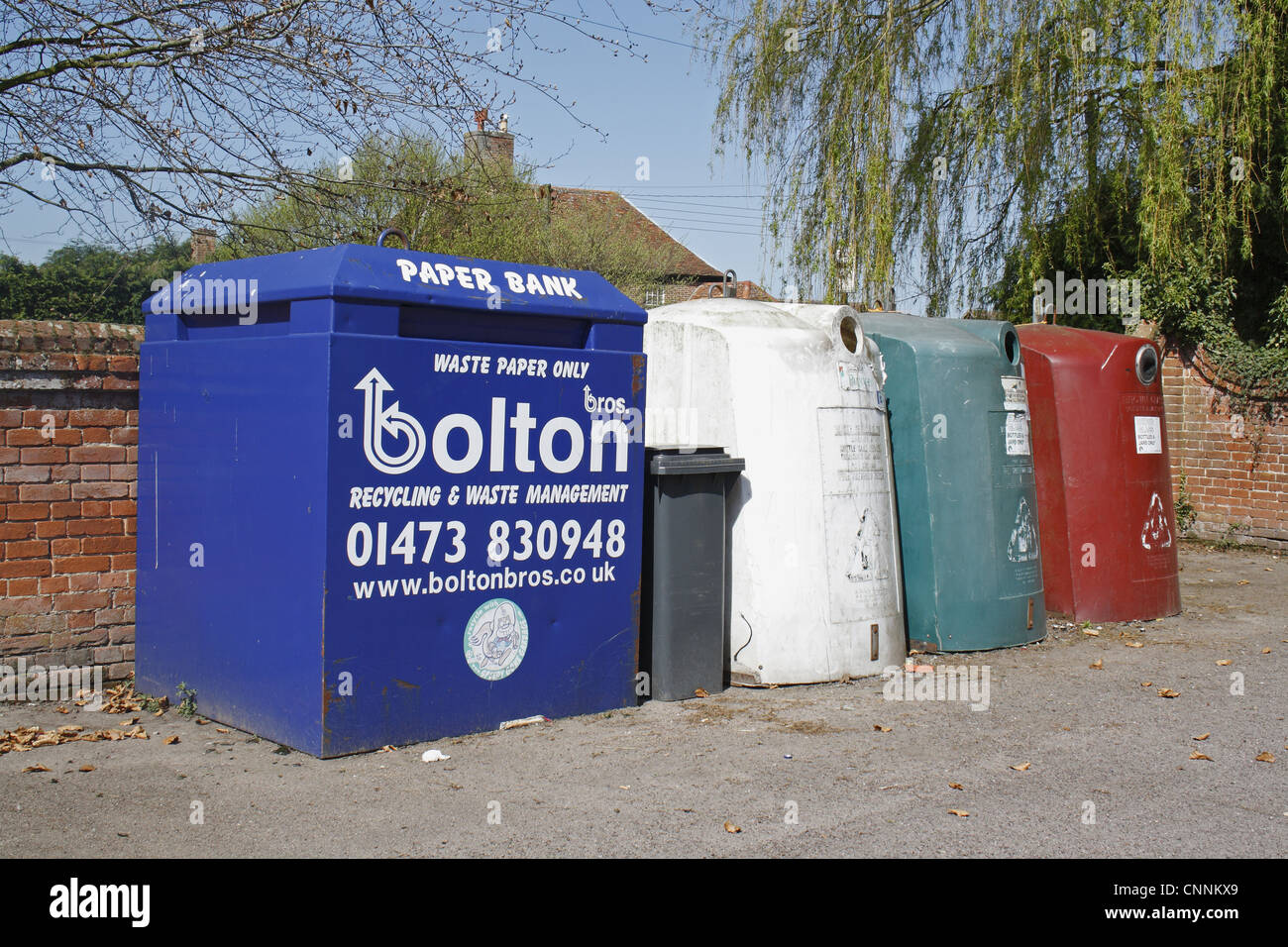 Pour les banques de recyclage du papier et du verre, en parking de village hall, aboiements de Tye, Suffolk, Angleterre, avril Banque D'Images