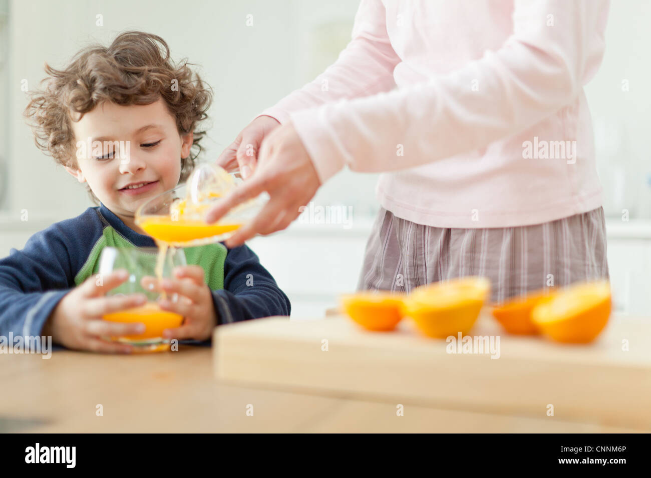 Verser Le Jus D Orange Pour Mere Fils Photo Stock Alamy