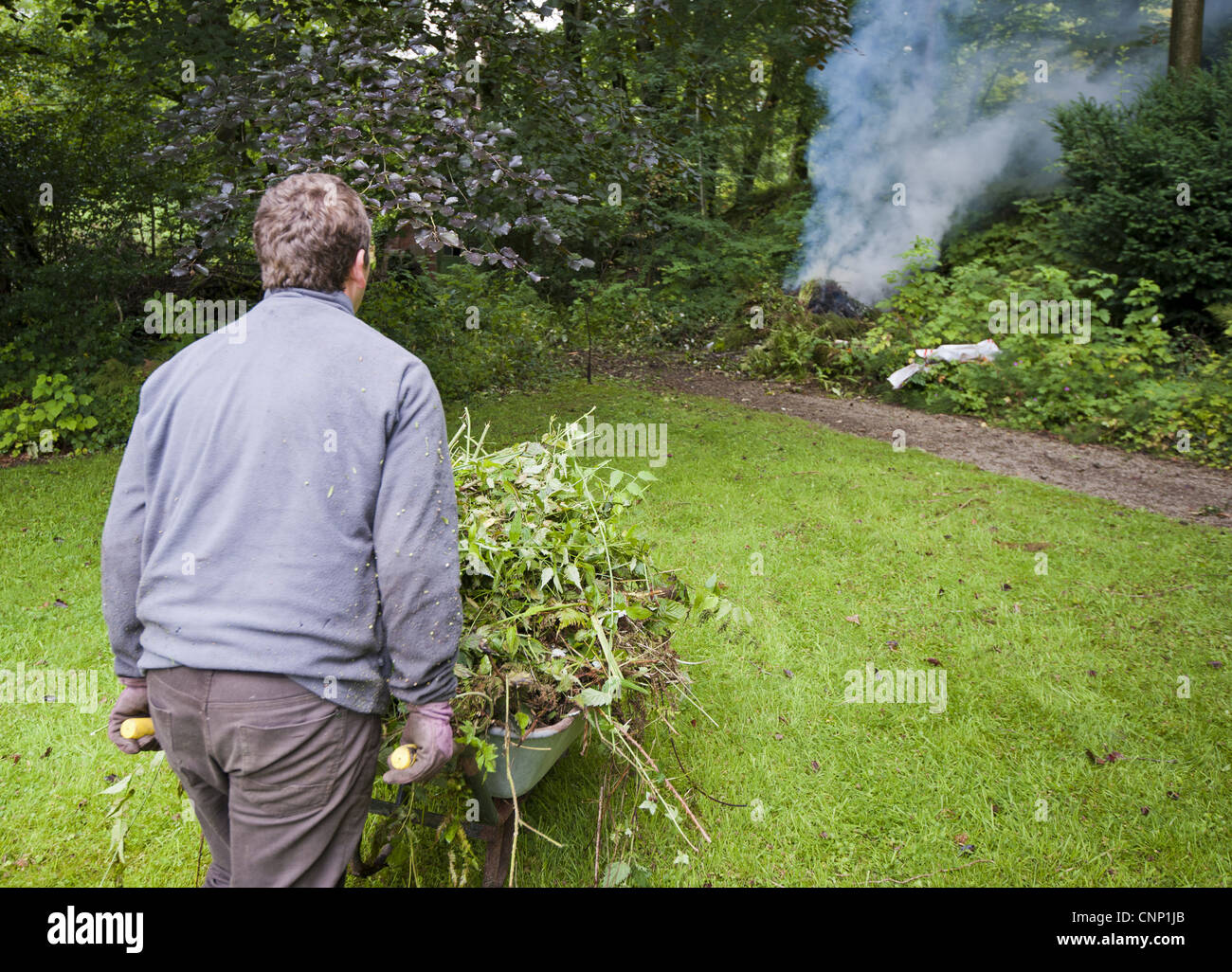 La combustion de déchets de jardin jardinier sur Bonfire, écaillage, Lancashire, Angleterre, août Banque D'Images