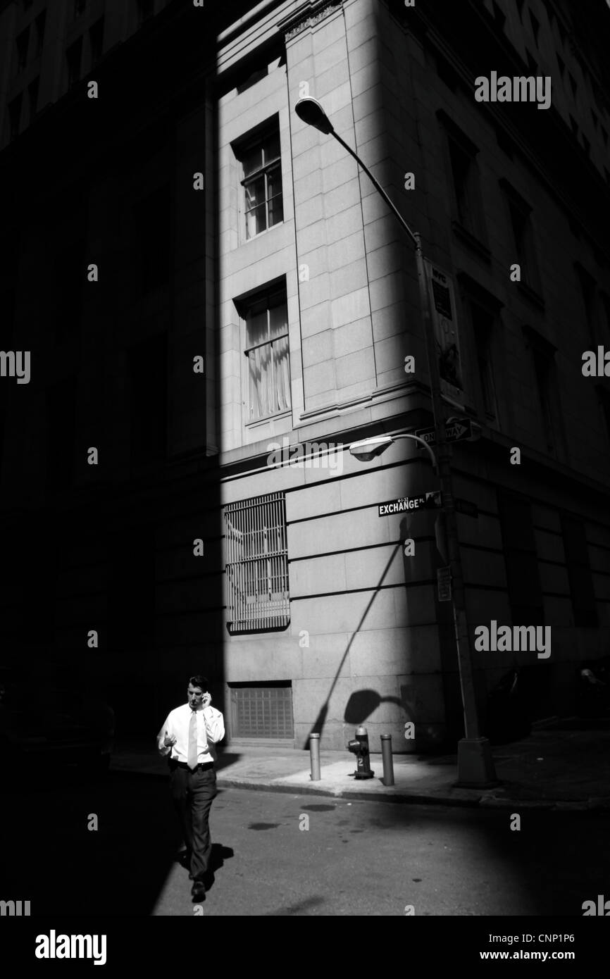 Un business man talking on a cell phone au lieu d'échanges à Wall Street de New York City, USA Banque D'Images