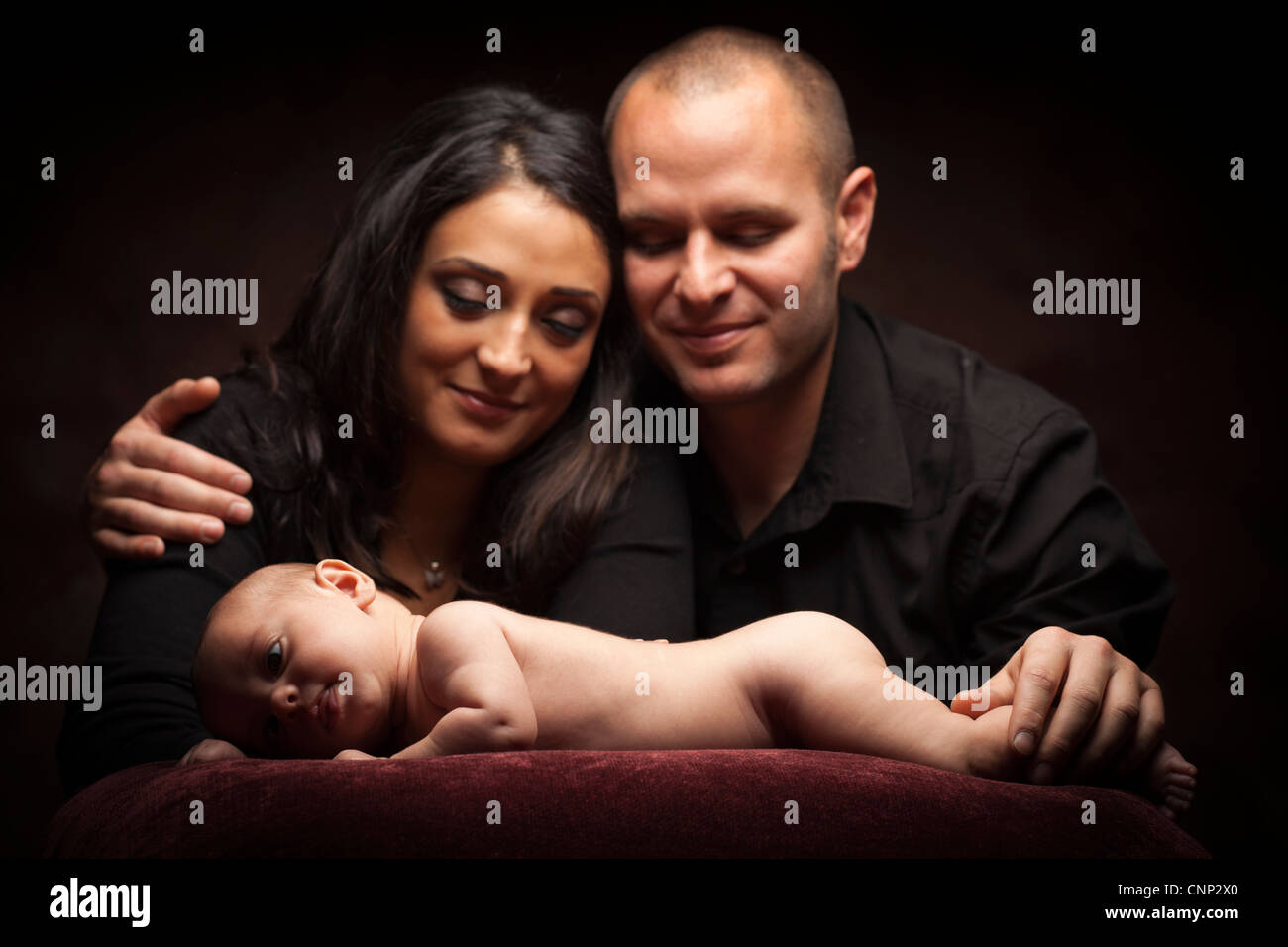 Mixed Race Couple Regarder Avec Amour Sur Tout Bebe Jette Sur Oreiller Sur Un Fond Sombre Photo Stock Alamy