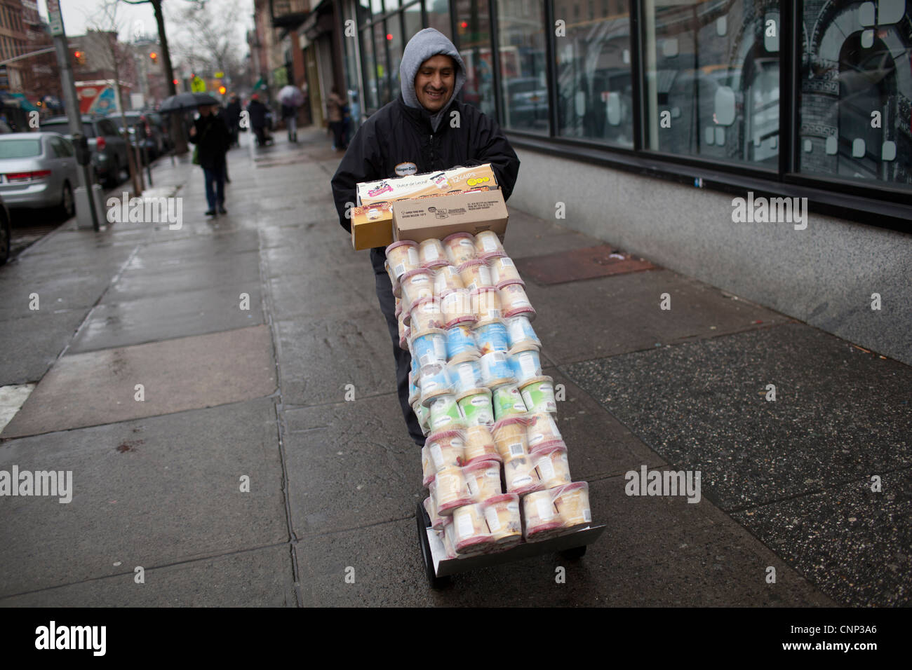 La prestation d'un homme pousse un chariot chargé avec Haagen-Das crème glace à Brooklyn, New York. Banque D'Images
