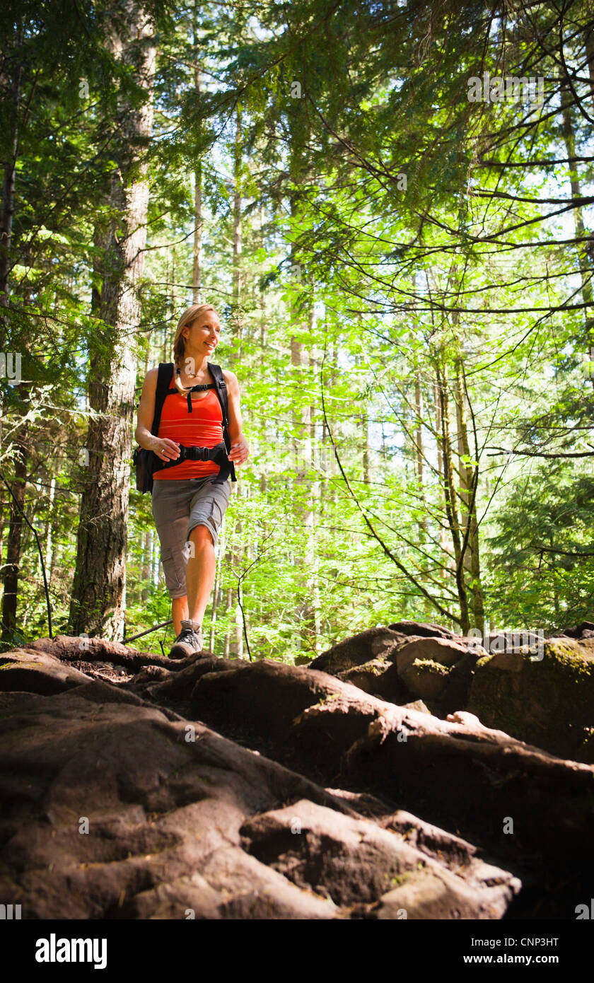Une femme marche d'un sentier dans la forêt, si peu de trail, Washington, USA. Banque D'Images