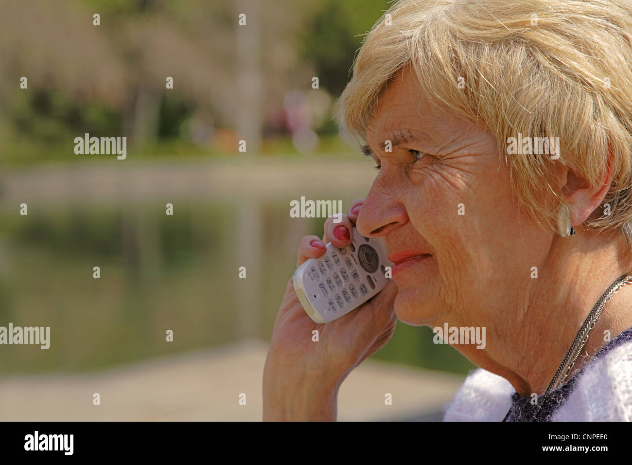 Profil d'une femme senior à l'aide d'un téléphone mobile. Banque D'Images