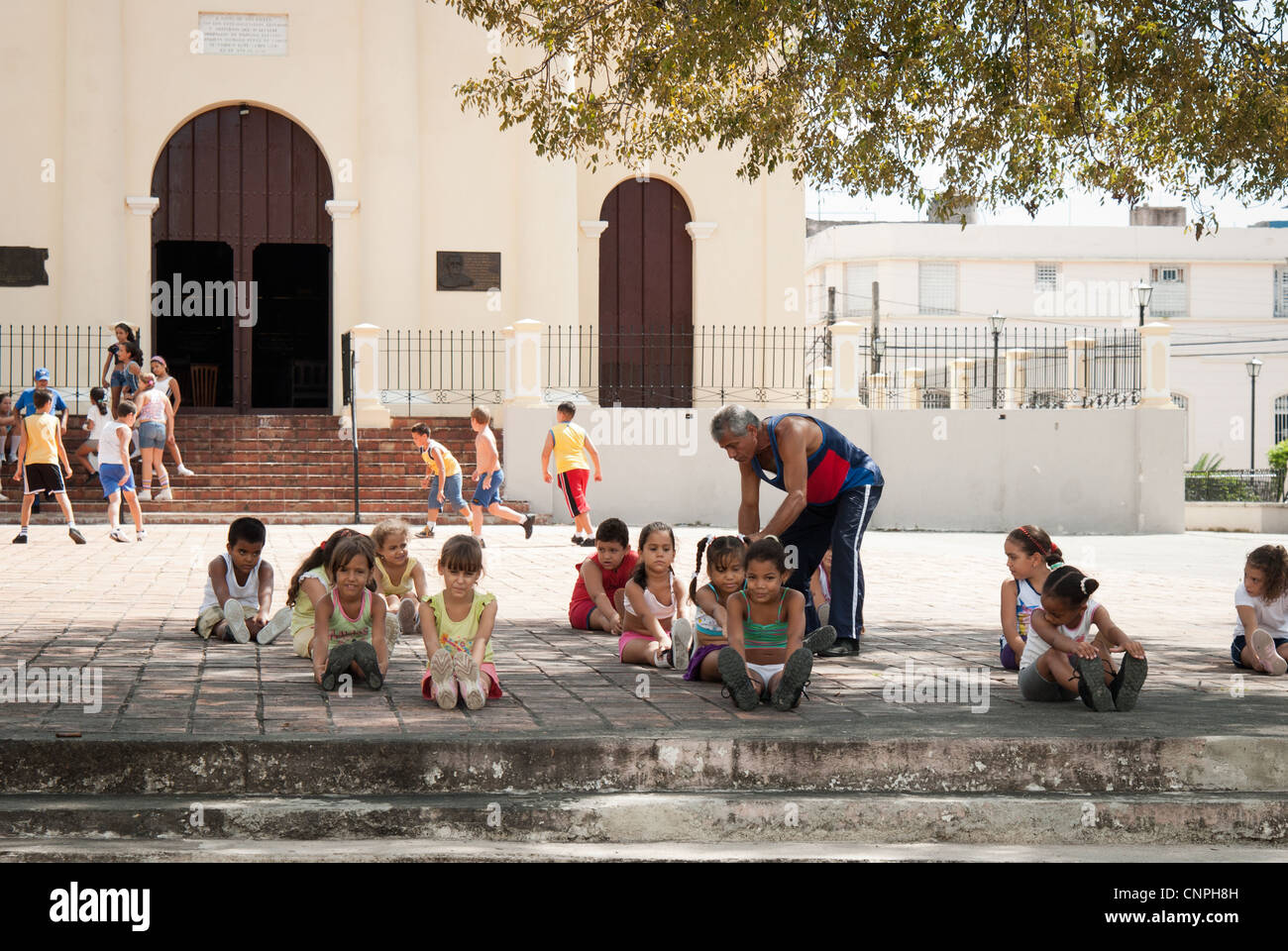 Filles cubaines pendant leur leçon en dehors d'un PE dans l'église Santa Clara. Ale garçons jouant au football dans l'arrière-plan Banque D'Images