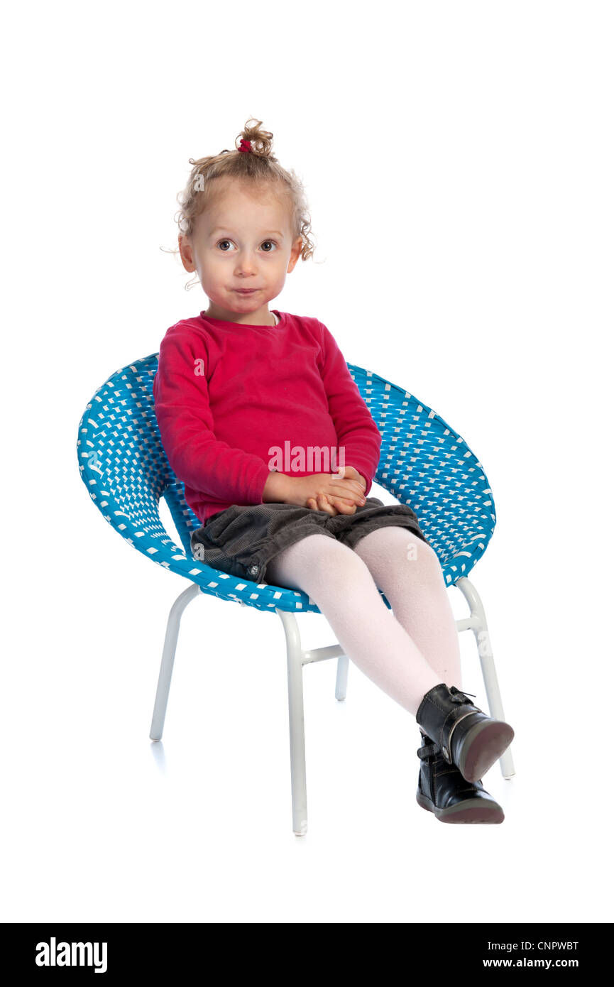 Jolie petite fille assise dans un fauteuil bleu ronde. isolé sur fond blanc Banque D'Images
