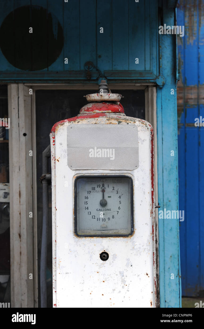 Ancienne pompe à essence contre fond bleu dans garage abandonné Banque D'Images