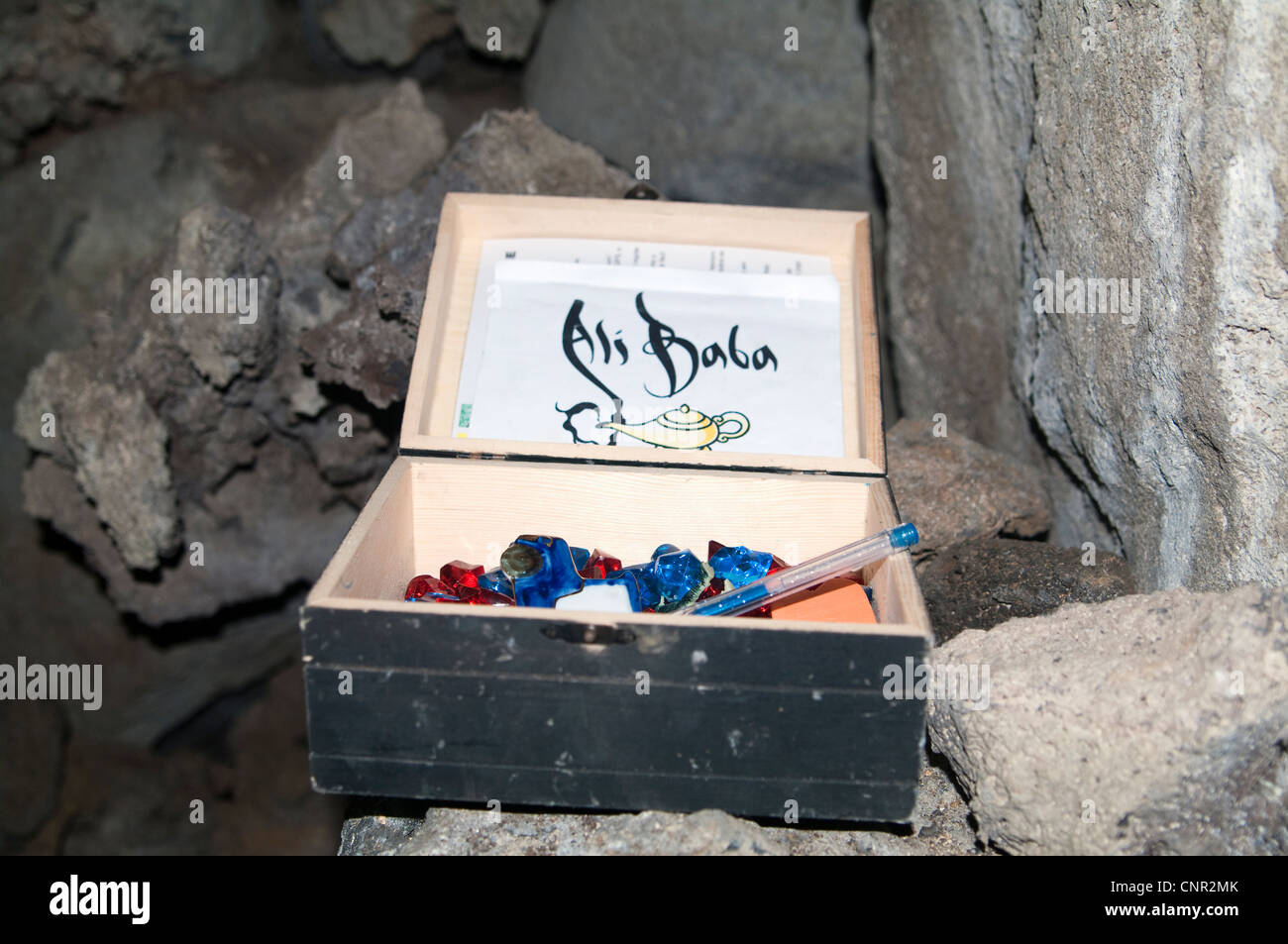 Conteneur de géocaching étiqueté “Ali Baba” caché dans une grotte aux Açores, Portugal. La boîte en bois contient un journal de bord étiqueté 'Ali Baba'. Banque D'Images