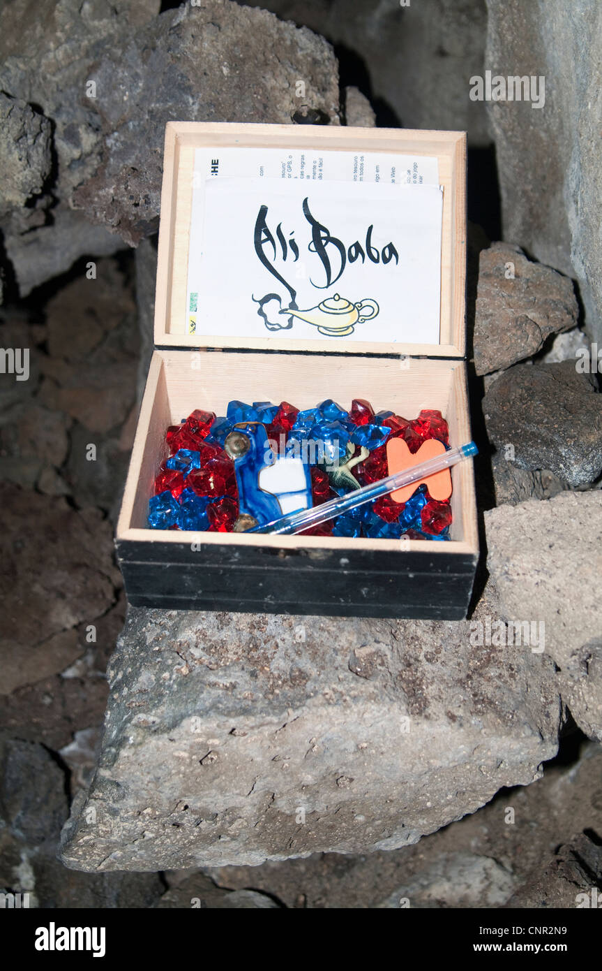 Conteneur de géocaching étiqueté “Ali Baba” caché dans une grotte aux Açores, Portugal. La boîte en bois contient un journal de bord étiqueté 'Ali Baba'. Banque D'Images