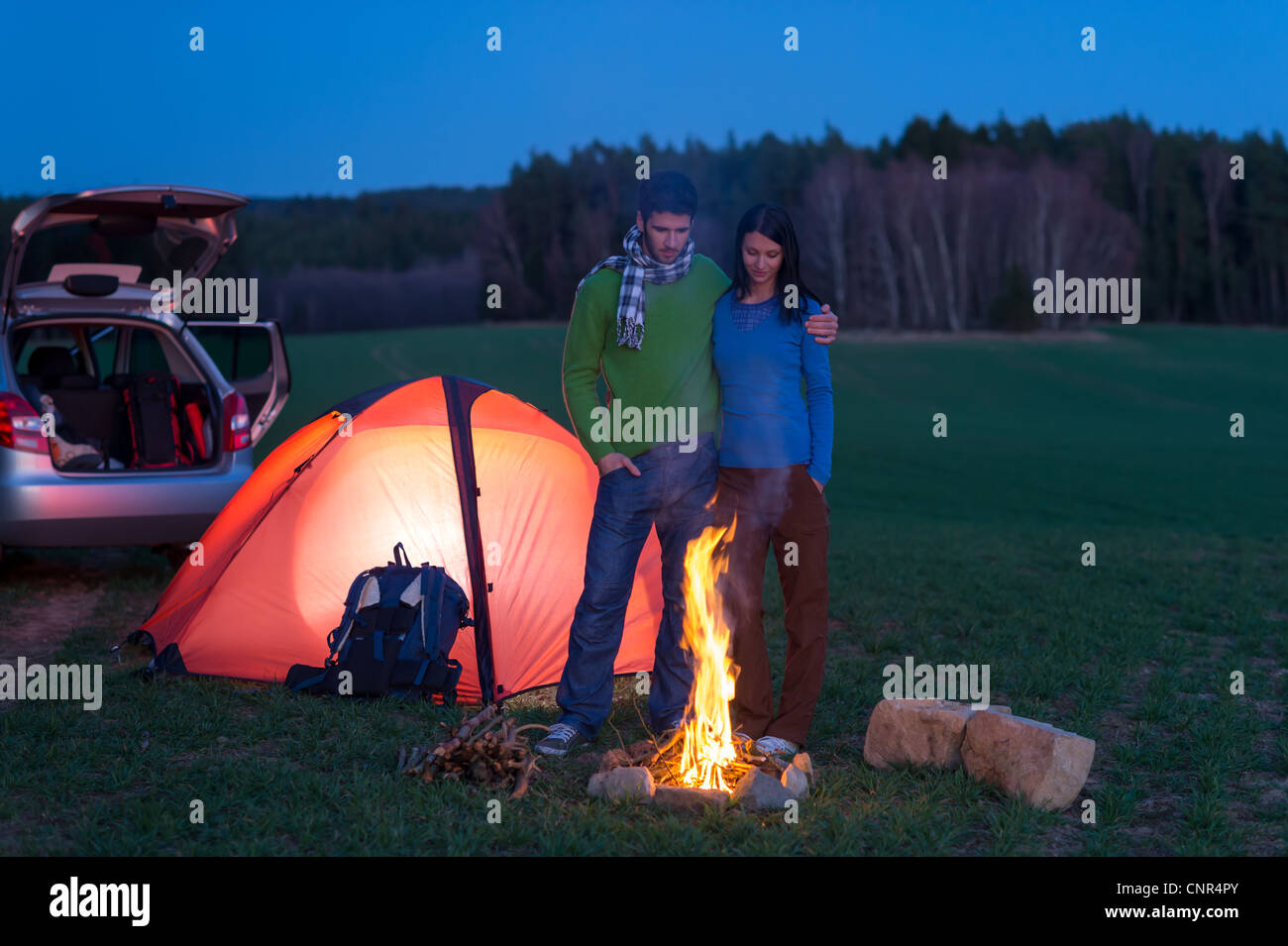 Tente camping car couple stand romantique par bonfire night campagne Banque D'Images
