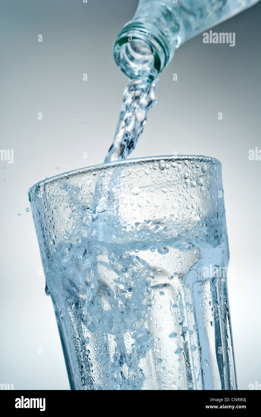 Close-up de l'eau minérale qui est versé dans un verre. Banque D'Images