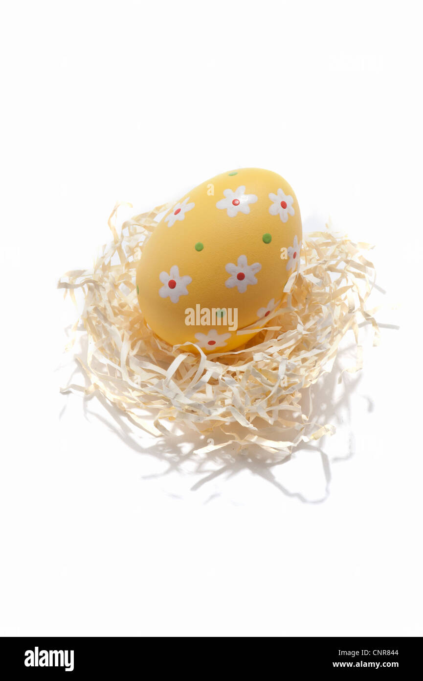 Un oeuf de Pâques décorés sur un nid de paille papier Banque D'Images