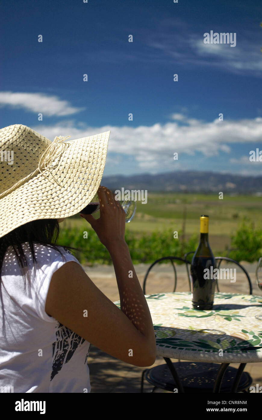 Femme buvant du vin à table outdoors Banque D'Images