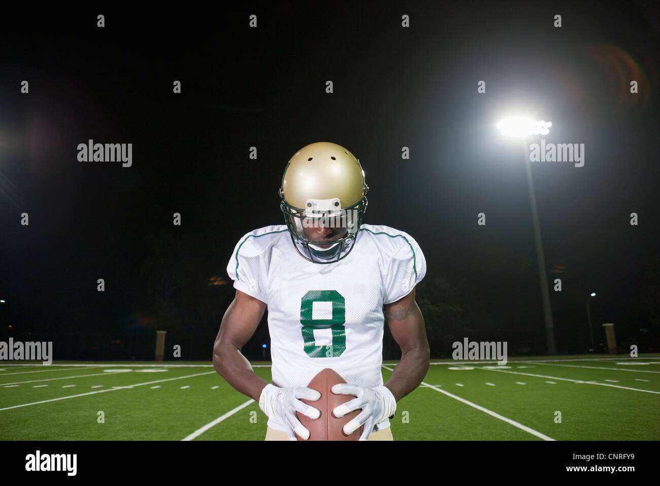 Football player holding ball, la tête en bas, dans la concentration Banque D'Images