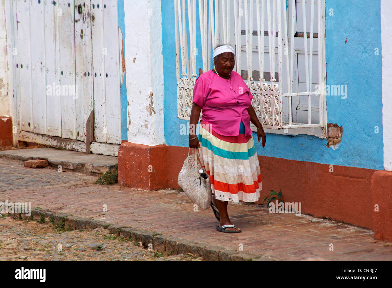 La vie quotidienne à Cuba - Afro-caraïbes femme portant des vêtements de couleur vive le shopping street à Trinidad, Cuba Banque D'Images