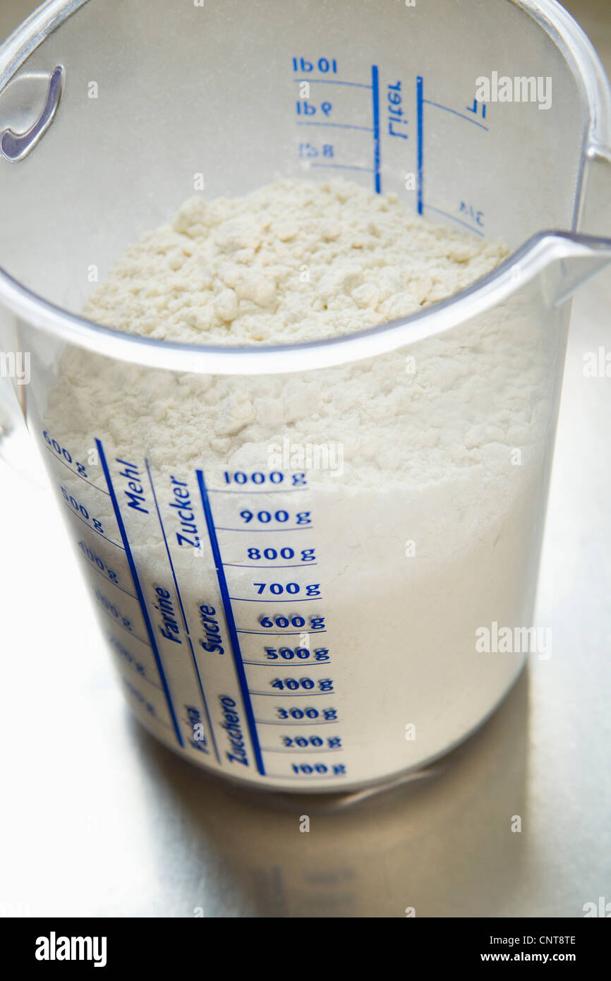Tasse à mesurer dans la farine Photo Stock - Alamy