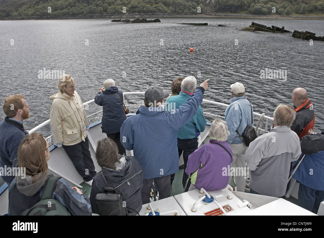 Guide sur un bateau touristique montrant des épaves qui sont hors de l'eau permanent pour les visiteurs, Royaume-Uni, Ecosse Banque D'Images