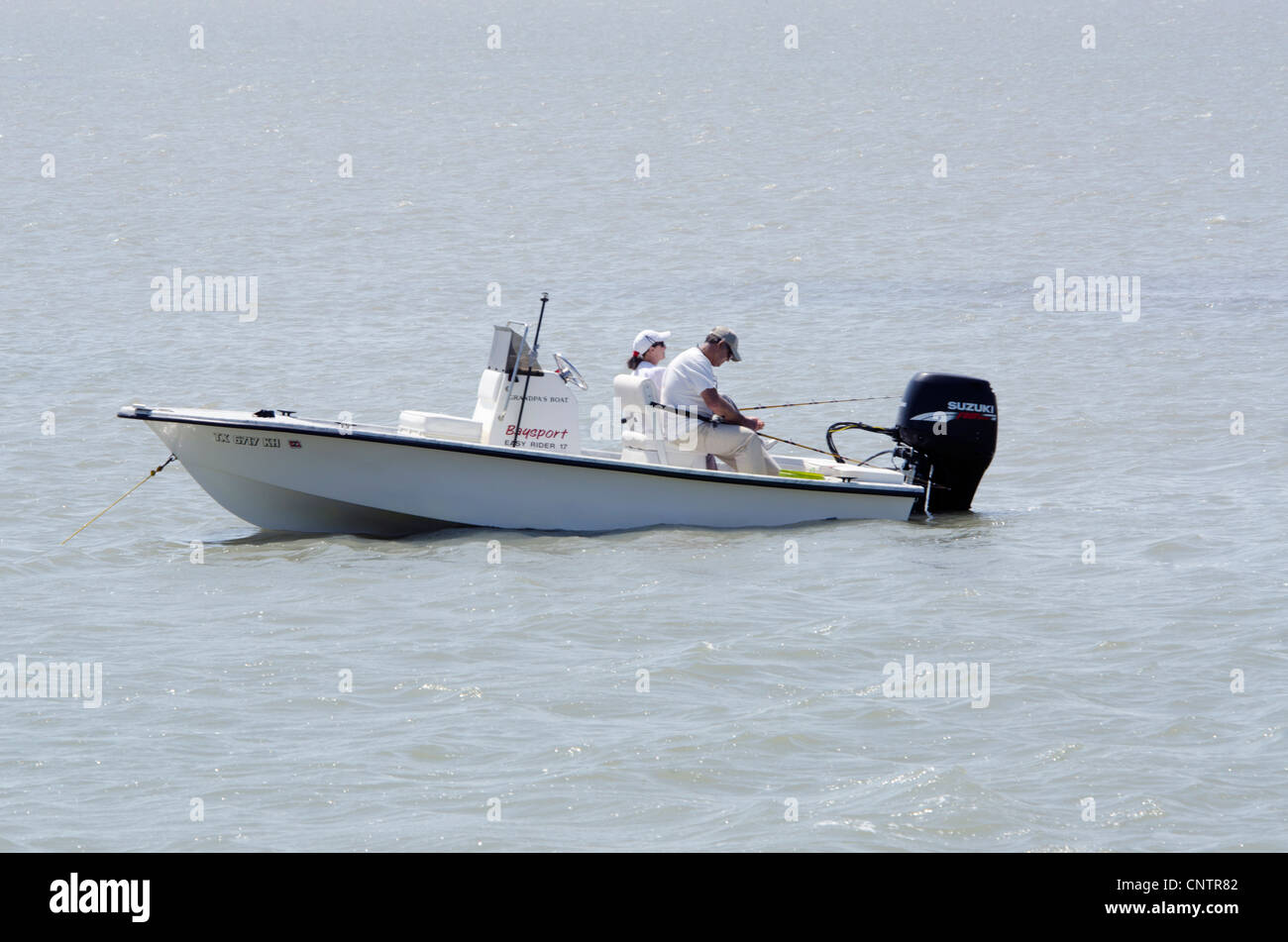 Un homme de race blanche et de la femme poisson d'un bateau dans le golfe du Mexique, les îles-barrières près de Rockport, Maine, USA. Banque D'Images