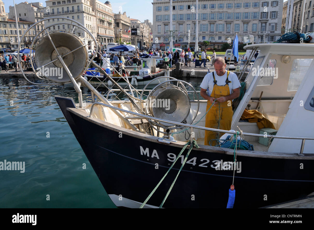 Un pêcheur trier ses lignes de pêche au vieux port à Marseille, France Banque D'Images