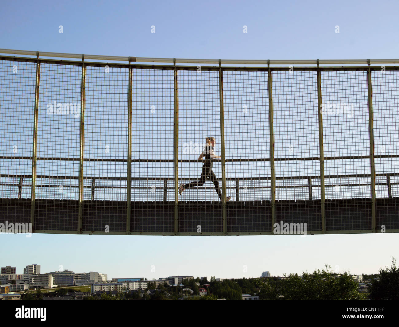 Runner crossing skybridge Banque D'Images