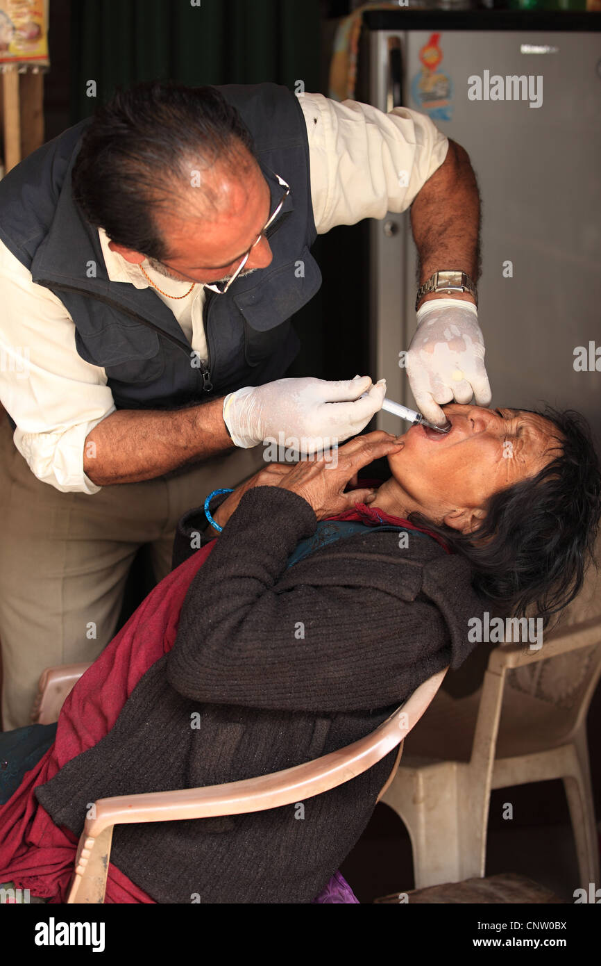 Dentiste rural népalais avec vieille femme malade au Népal Banque D'Images