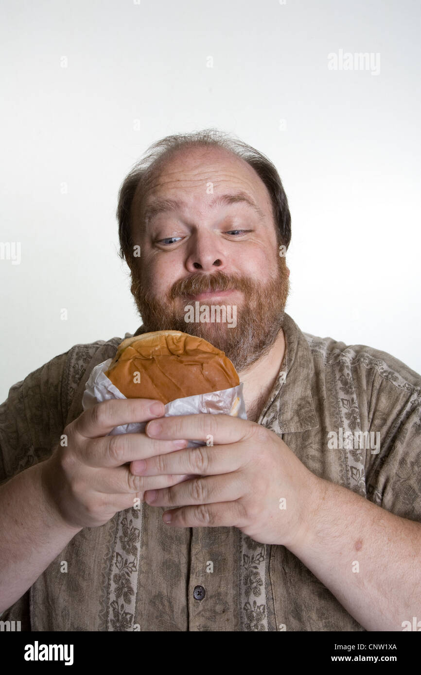 L'excès de l'homme dans la mi-quarantaine eating fast food Banque D'Images