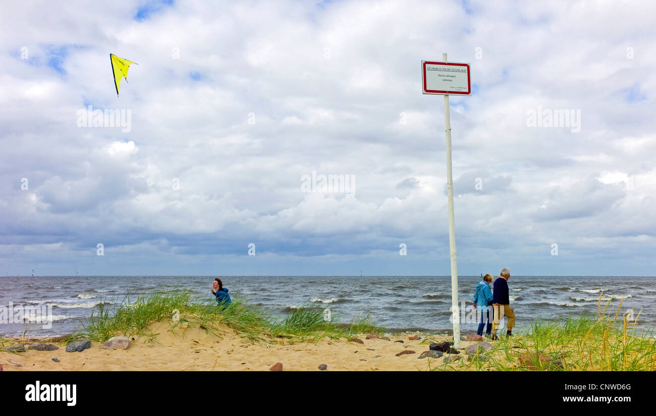Les gens qui marchent sur la plage, dans le mauvais temps, l'ALLEMAGNE, Basse-Saxe, Cuxhaven Banque D'Images