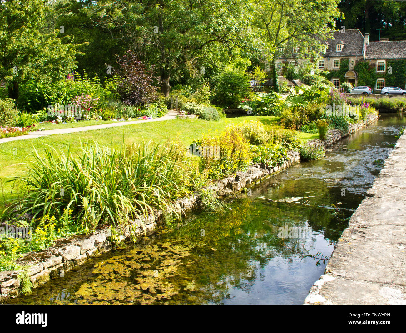 Vue de Bibury Trout Farm dans le joli village de Cotswold anglais en Bibury Gloucestershire England UK.Swan Hotel à distance. Banque D'Images