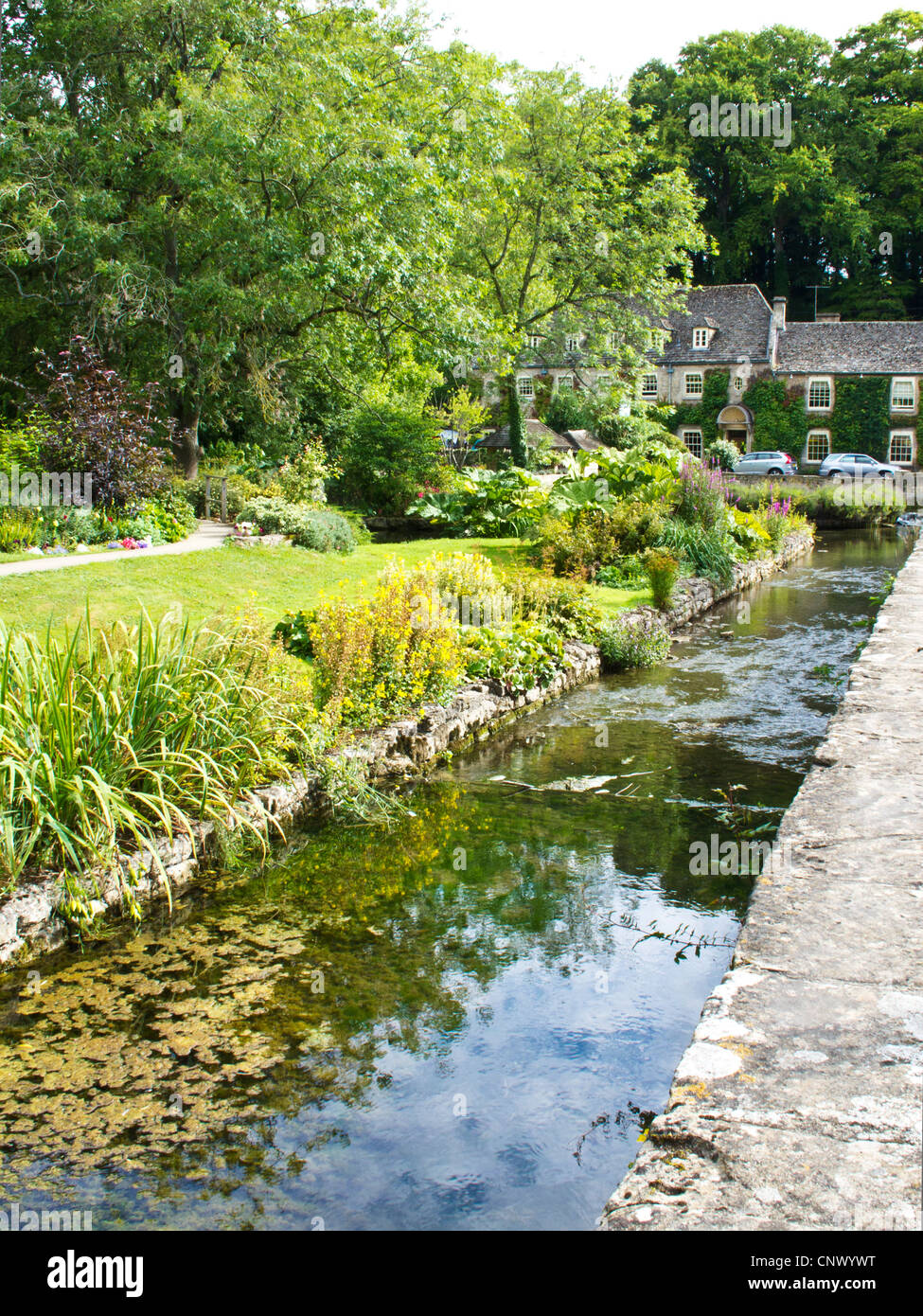 Vue de Bibury Trout Farm dans le joli village de Cotswold anglais en Bibury Gloucestershire England UK.Swan Hotel à distance. Banque D'Images