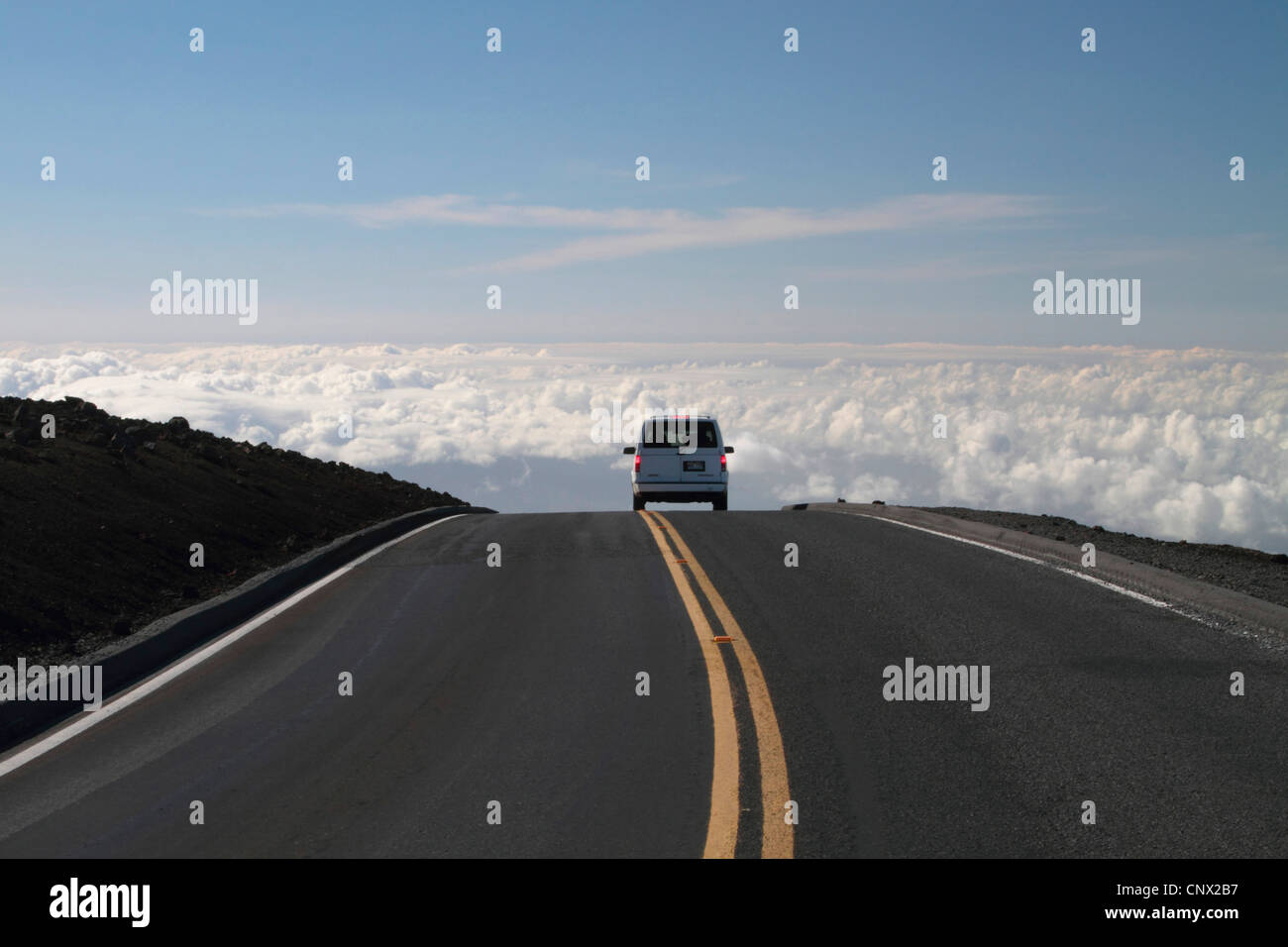 Voiture voyageurs sur une route sur les nuages au sommet du volcan Haleakala (3000 m), USA, Hawaii, Maui Banque D'Images