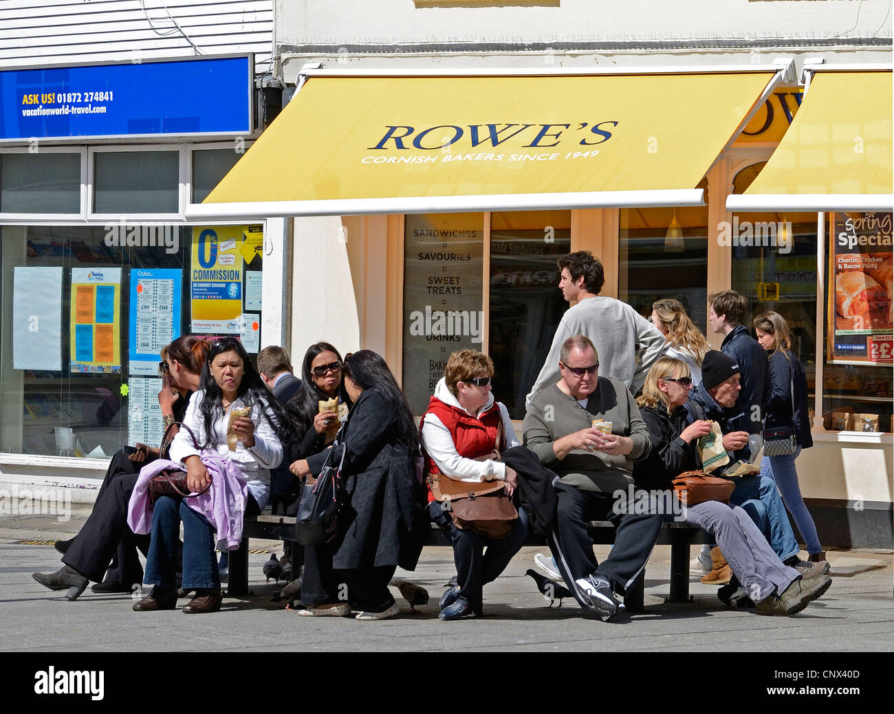 Les touristes de manger à l'extérieur d'un cornish pasty shop à Truro, Cornwall, UK Banque D'Images