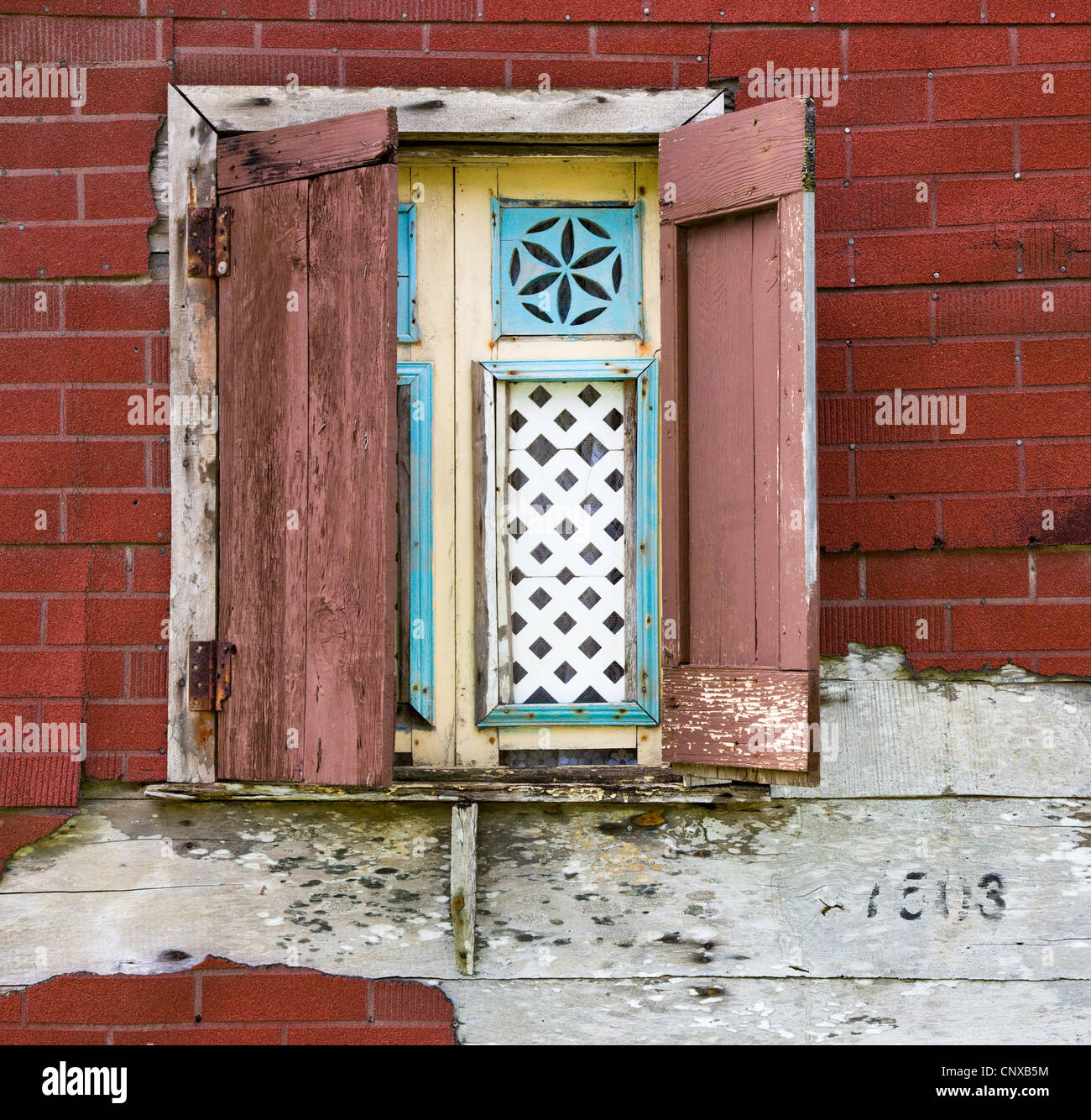Fenêtre à volets dans une maison en bois recouvert de tuiles d'effet de brique dans le village de Calibishie Dominique Antilles Banque D'Images