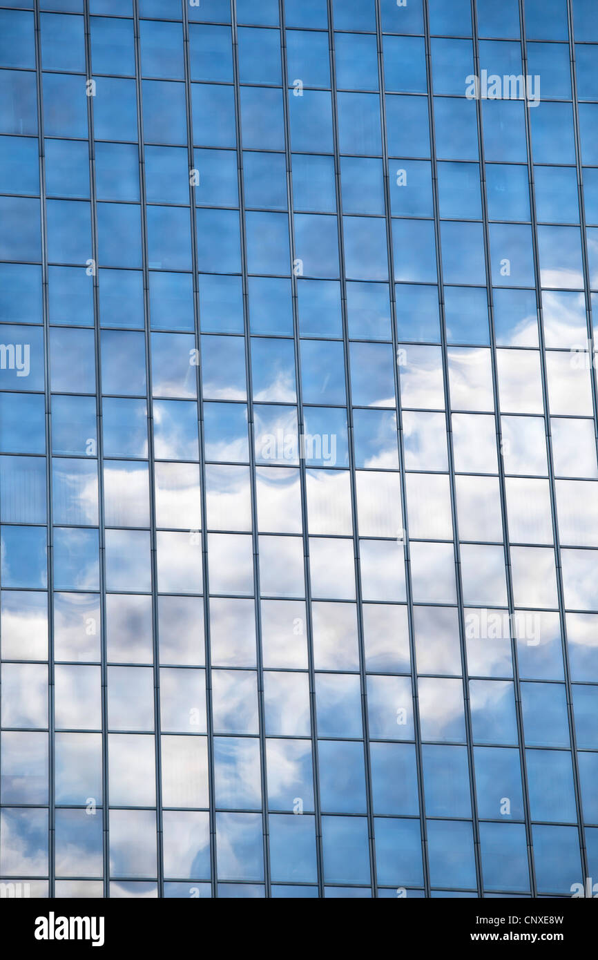 Les nuages et le ciel reflète dans windows en miroir d'un immeuble de bureaux Banque D'Images