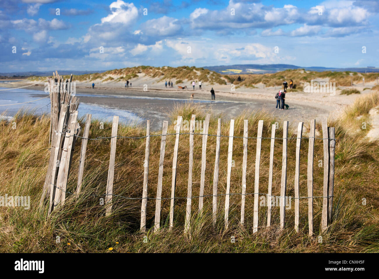 Vue de la tête de l'Est par West Wittering beach avec les marcheurs et les nuages.clôture de la cueillette. Banque D'Images