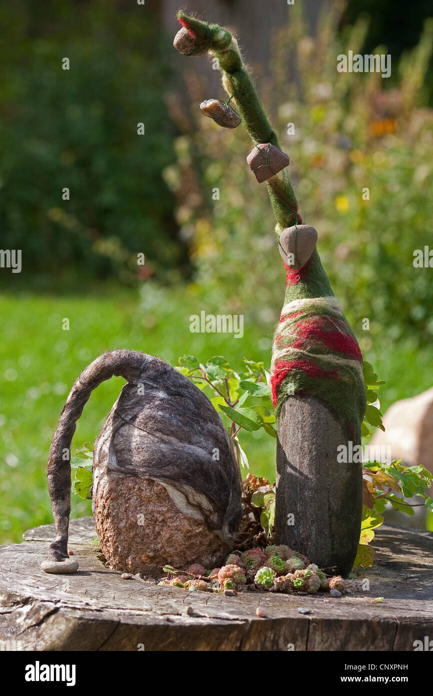 'Avis des trolls de pierre servant de décoration de jardin : deux pierres naturelles équipées de bouchons de laine feutrée côte à côte sur un arbre accroc, Allemagne Banque D'Images