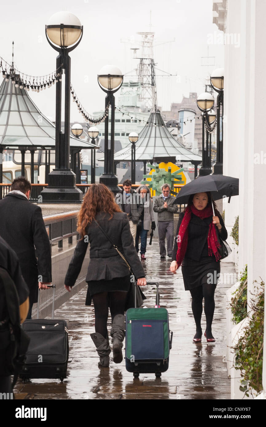 Le Pont de Londres , Southbank , coton , le centre du Queens à pied , les piétons avec parapluie et causes la marche dans la pluie par remblai Banque D'Images
