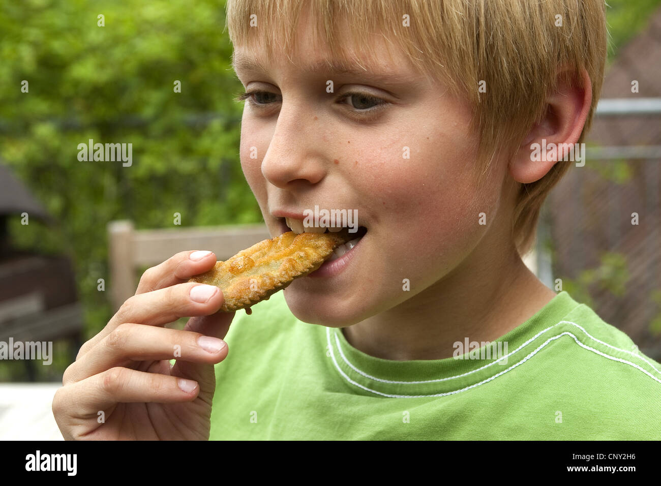 L'ortie (Urtica dioica), boy eating a laisser dans la pâte frit, Allemagne Banque D'Images