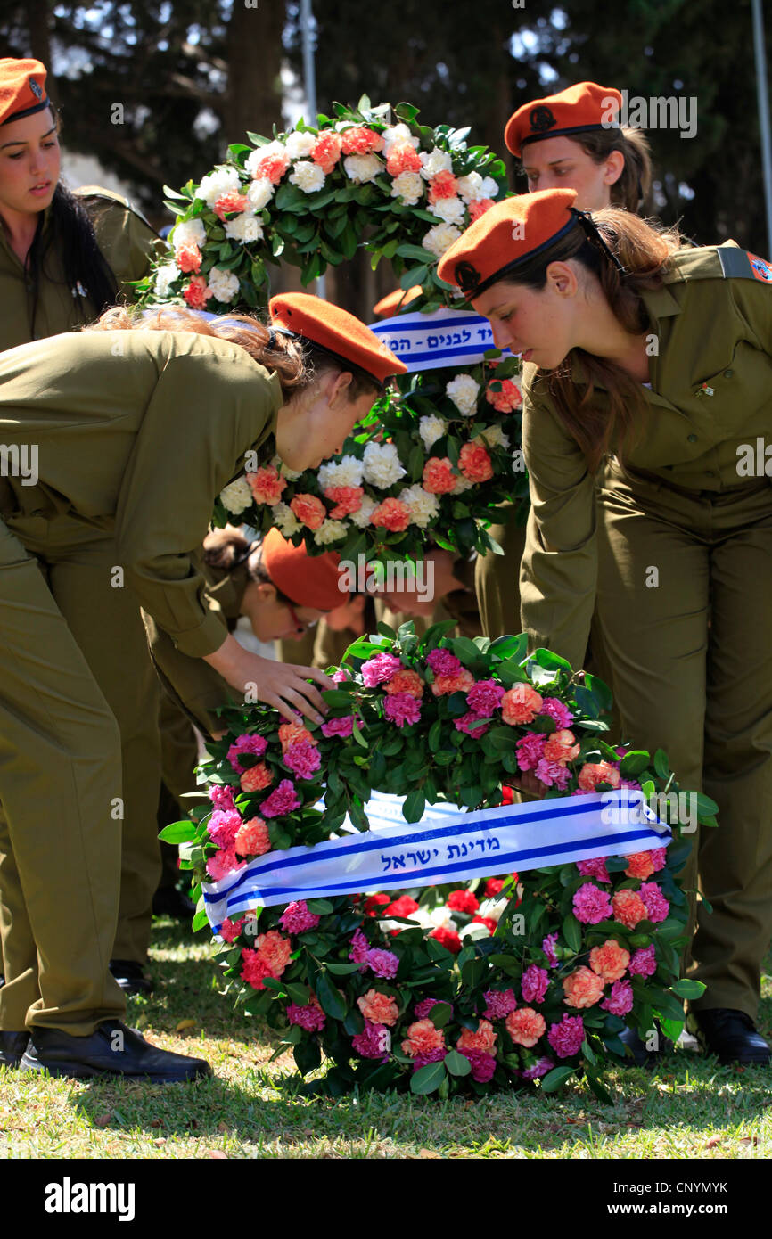 Femmes soldats israéliens portent des couronnes au cours d'une cérémonie commémorative en l'honneur des soldats sur Yom Hazikaron Memorial Day pour les soldats tombés à Kiryat Shaul cimetière juif dans le nord de Tel Aviv, Israël Banque D'Images