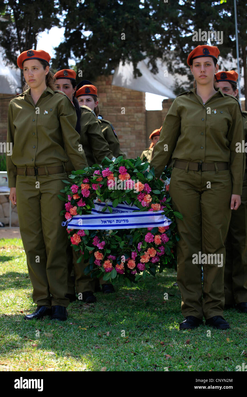 Femmes soldats israéliens portent des couronnes au cours d'une cérémonie commémorative en l'honneur des soldats sur Yom Hazikaron Memorial Day pour les soldats tombés à Kiryat Shaul cimetière juif dans le nord de Tel Aviv, Israël Banque D'Images