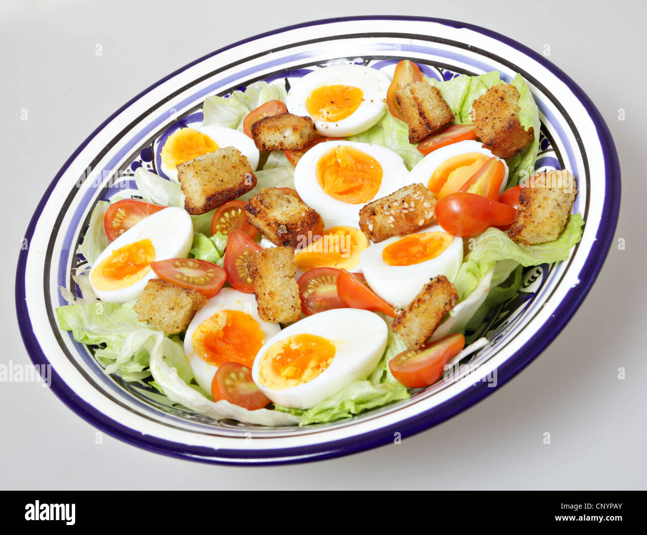 Un bol de salade avec des oeufs durs, tomates miniatures, iceburg et laitue croûtons maison Banque D'Images