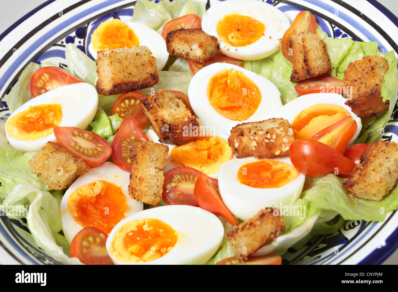 Une salade d'oeufs durs, tomates miniatures, iceburg et laitue croûtons maison Banque D'Images