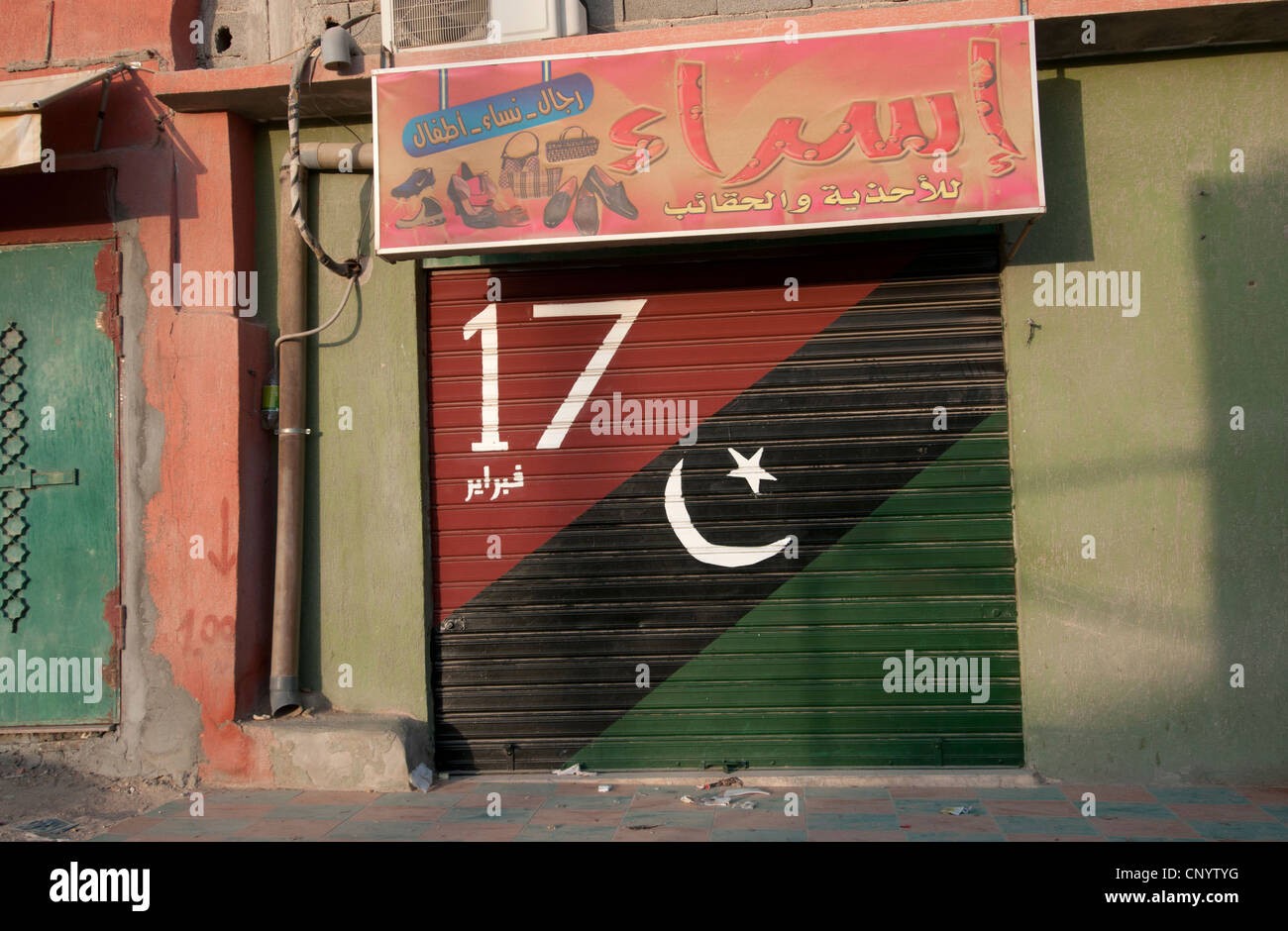Nalut. Le drapeau libyen Kadhafi post est peint sur l'obturateur fermé d'une boutique, ainsi que la date de la révolution de février 17ème Banque D'Images