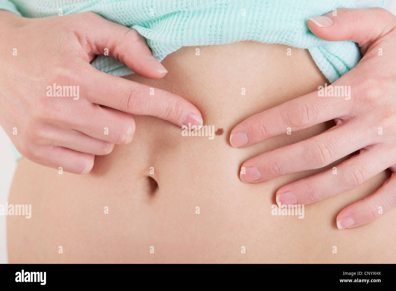 Femme montrant un point sur le ventre Banque D'Images