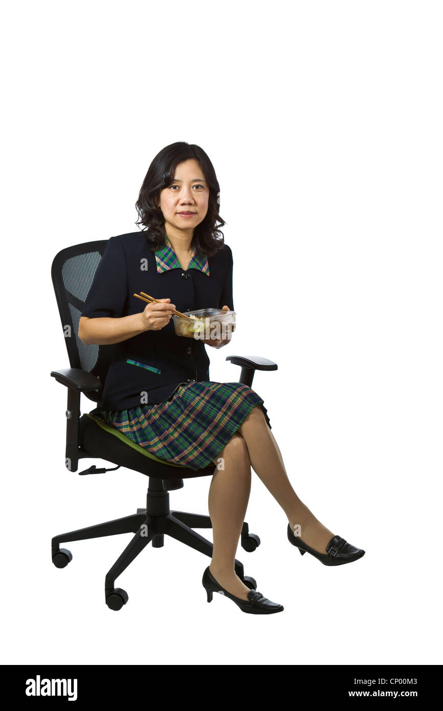 Asian women in business vêtements causale holding le déjeuner tout en restant assis dans la chaise sur fond blanc Banque D'Images