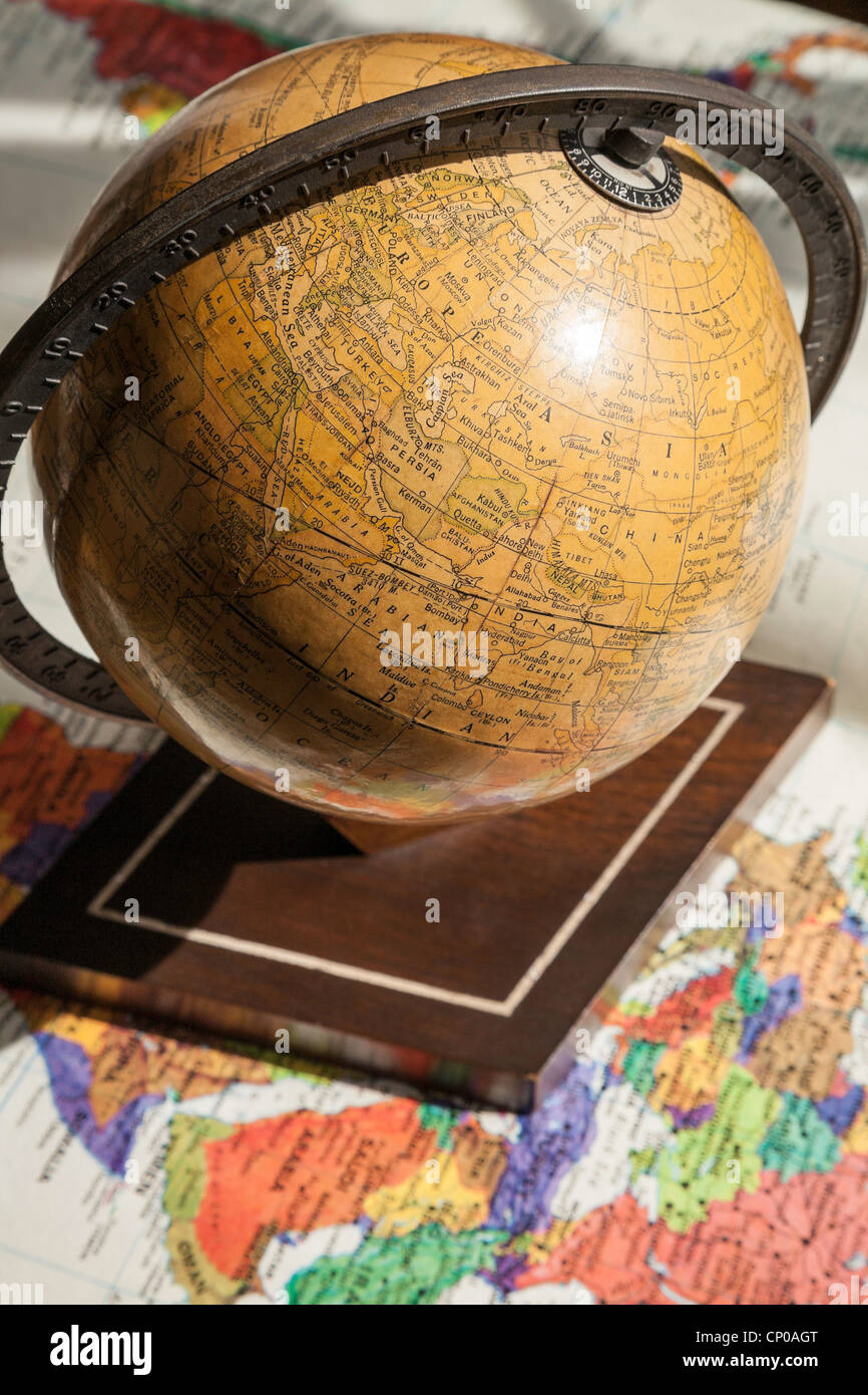 Vintage 1930's world globe sur le stand sur la carte du monde. Banque D'Images