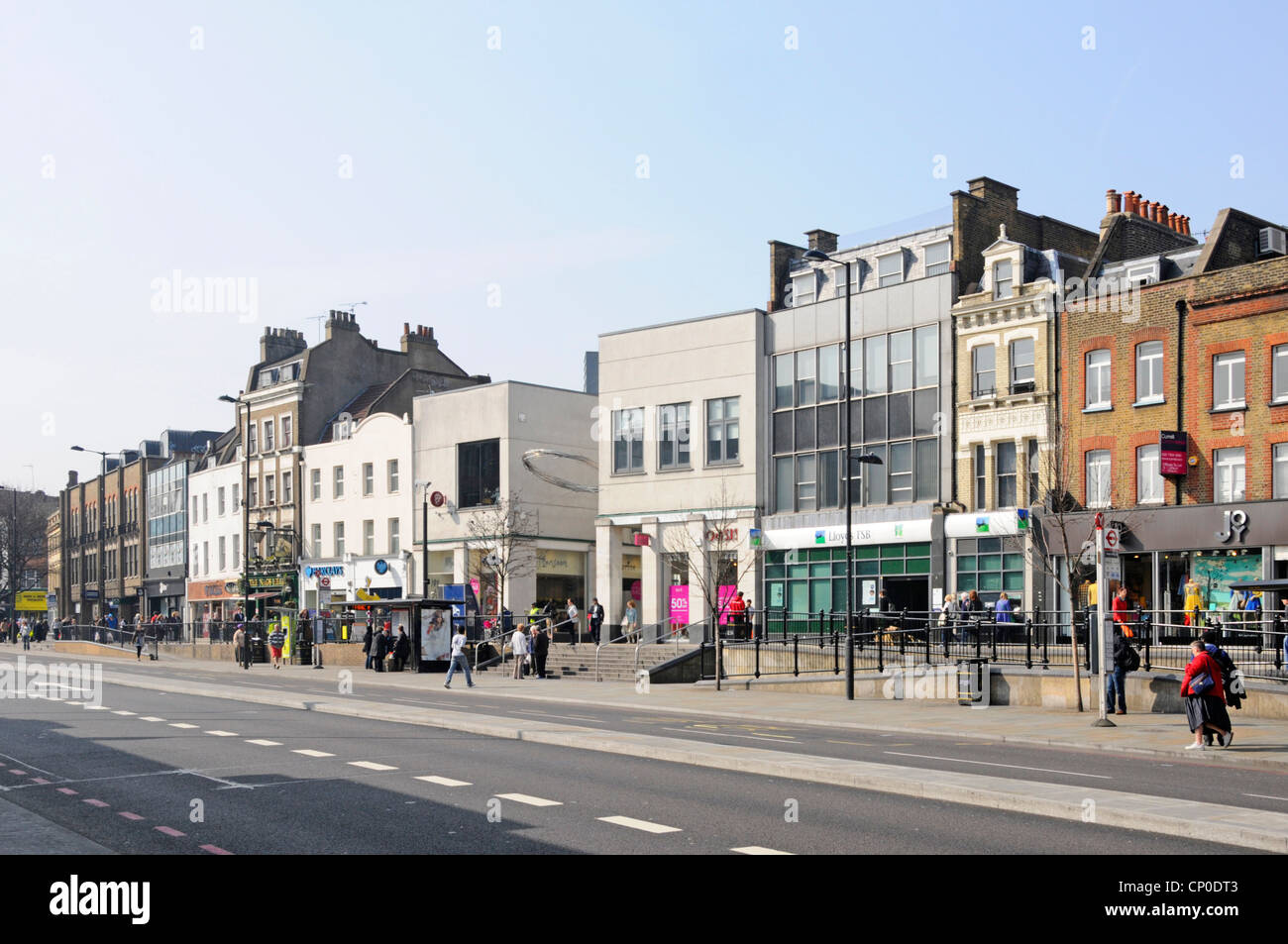 Les gens dans Upper Street scène hivernale ensoleillée, y compris les magasins de détail Et les locaux d'affaires Islington Londres Angleterre Royaume-Uni Banque D'Images