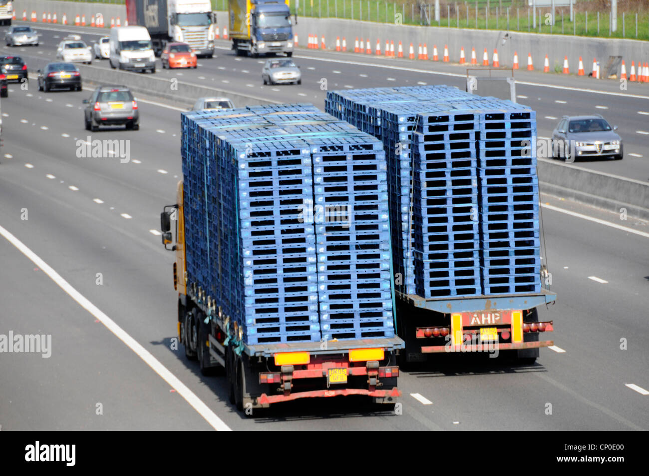Image de transport vue arrière depuis le dessus deux camions camion remorque articulée hgv camions chargés de palettes en bois bleu sur l'autoroute britannique Banque D'Images