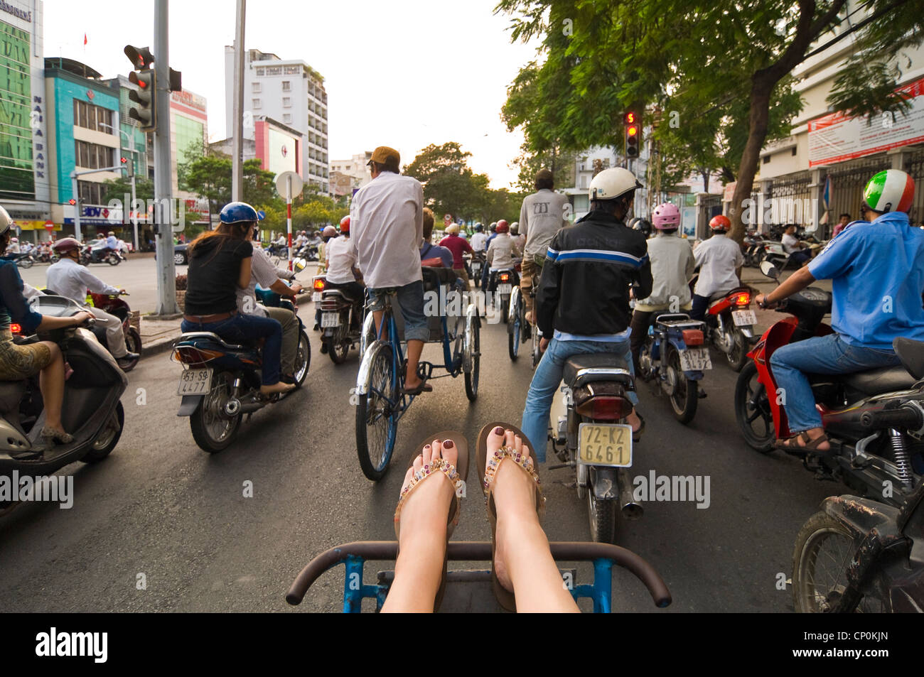 Vue horizontale d'un tourisme de l'Ouest sur cycle rickshaw qui transitent par le trafic important sur les rues folles de Ho Chi Minh Ville Banque D'Images