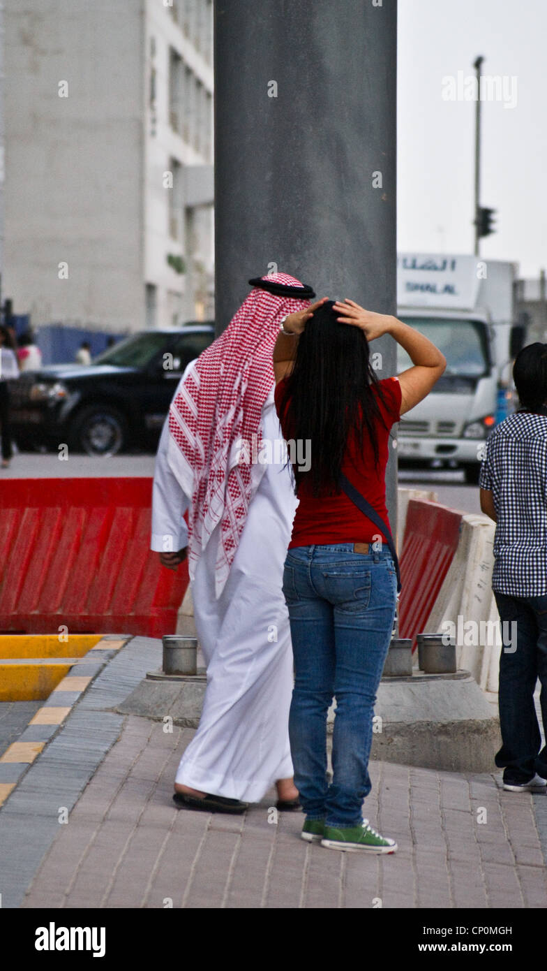 Un homme en costume traditionnel arabe et une jeune femme en jeans et  t-shirt, dans la rue, Dubaï, Emirats Arabes Unis vue arrière Photo Stock -  Alamy